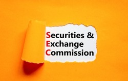 SEC securities and exchange commission symbol. Concept words SEC securities and exchange commission on white paper on a orange background. Business SEC securities exchange commission concept.