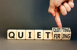 Quiet quitting or firing symbol. Concept words Quiet quitting Quiet firing on cubes. Businessman hand. Beautiful grey table grey background. Business quiet quitting or firing concept. Copy space.