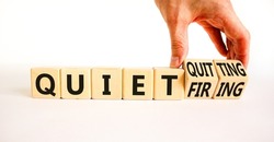Quiet quitting or firing symbol. Concept words Quiet quitting Quiet firing on cubes. Businessman hand. Beautiful white table white background. Business quiet quitting or firing concept. Copy space.