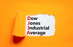 DJIA Dow Jones industrial average symbol. Concept words DJIA Dow Jones industrial average on white paper on beautiful orange background. Business DJIA Dow Jones industrial average concept. Copy space