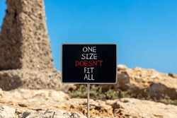 One size does not fit all symbol. Concept words One size does not fit all on beautiful black chalkboard. Beautiful stone blue sky background. One size does not fit all business concept. Copy space.