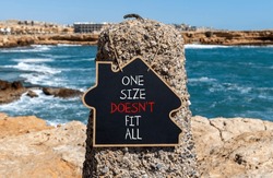 One size does not fit all symbol. Concept words One size does not fit all on beautiful black chalkboard. Beautiful stone sea background. One size does not fit all business concept. Copy space.
