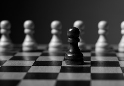 One unique pawn outstanding from many opposits. Concept of individual, different, standout. Black and white.