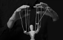 Hands manipulating puppet. Master of marionette in action.