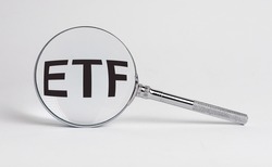 ETF analysis concept. Word through magnifying glass. High quality photo