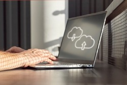 Cloud computing. Man using laptop for upload, storage, download or sharing files and data online. Male hands on computer keyboard closeup. High quality photo