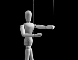 Puppet on strings. Authority, domination, influence concept. Marionette in human hand. World conspiracy. Shadow government. Black and white. High quality photo