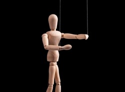 Puppet on strings. Manipulation, control, power, abuse concept. Marionette in human hand. High quality photo