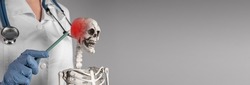 Banner with doctor hand pointing to skeleton skull with red point. Neuralgia, headache. Skeletal system anatomy, medical education concept. Copy space. High quality photo