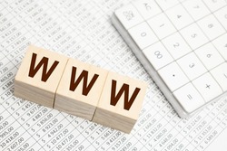 WWW website url of three words on wooden cube block, minimal background concept for internet connection, magnifier on golden background with reflection.
