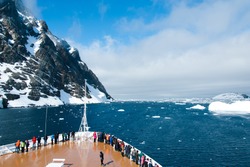 Mountains and cruise ship in Antarctica in sunny day