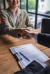 Business people shaking hand after business signing contract and resume on desk in meeting room at company office, job interview, investor, negotiation, partnership and teamwork Partnership concept