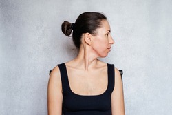 McKenzie method exercise to relieve neck pain, a woman gently rotates her head while doing neck pain relief exercises
