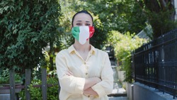 Woman with Italy flag mask. Woman  wearing a protective mask and helmet. Under the chin, protective mask with the Italy flag. Her mask is on her chin.