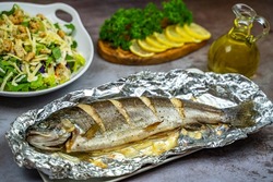 Oven baked trout in foil and salad. 