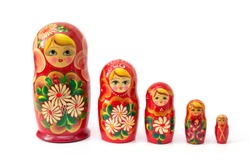 Bright colored nesting dolls on a white background. Russian national souvenir. A row of red nesting dolls of different sizes. Handmade work. Authentic Russian souvenir, hand-painted nesting dolls