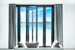 view seascape beautiful tropical beach and blue sky sea and sky, thailand  from black Aluminum door with glass frame and wall in luxury resort