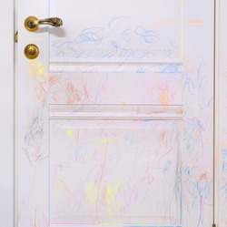 Child mischief. Child scribble on the wall, colored pencils scribbles on a white door