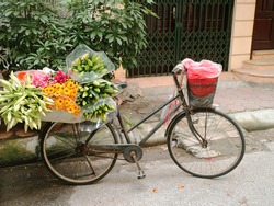 Empty Vintage Vietnamese Bicycle load Flower Multicolor Selling on Street rain coat in basket