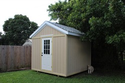 DIY project model backyard tool shed with a dog outside in a yard. Many trees are surrounding the shed.