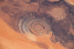 Aerial view of Richat Structure in Mauritania. Also called Guelb er Richât in Arabic Qalb ar-Rīšāt.  Digitally enhanced. Elements of this image furnished by NASA.