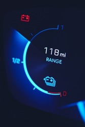 Close-in shot of electric car battery range gauge in blue
