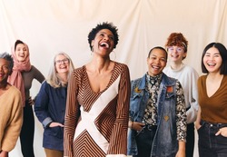 International Women's Day portrait of cheerful multi ethnic mixed age range women laughing and smiling