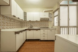 Kitchen with old white furniture, aluminum partitions with translucent glass and vintage tiled walls