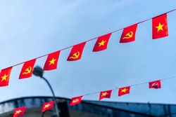 Vietnamese red with yellow star flag and Communist Party of Vietnam flag. Waving colorful national Vietnamese flag in blue sky. Politics and tourism concept