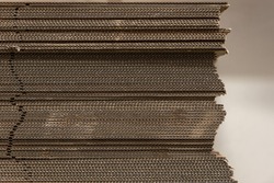 Detail of uneven stack of corrugated cardboard sheets with soft focus background