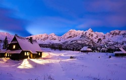 Forest hut on a winter snowy mountains. Mountain village in winter snow. Snowy mountain village houses