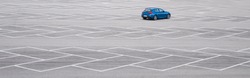 Blue car in an empty parking lot. Horizontal banner with copy space. Automobile without brand.