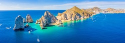 Aerial panoramic view of Lands End and El Arco at the tip of Baja California Sur, with the Cabo San Lucas, Mexico marina in the background