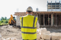 Foreman officer inspector, building Inspector, engineer or inspector at construction site checking and inspecting progressing work in construction site or building, in hardhat and high-visibility vest