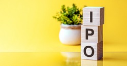 IPO - acronym from wooden blocks with letters, Initial Public Offering IPO concept, yellow background.Words: IPO in 3d wooden alphabet letters on a bright yellow background with copy space.