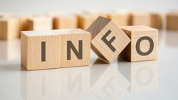 the word info is written on a wooden cubes structure. Blocks on a bright gray background. Selective focus.