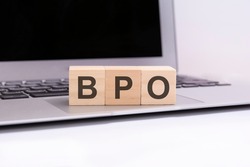 bpo - wooden cubes with letters on a silver laptop keyboard. BPO - short for Business Process Outsourcing. business conceptual word collected of of wooden elements with the letters.