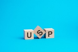 USP text on wooden blocks, financial business concept, blue background. USP - short for Unique Selling Proposition