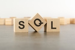 wooden cube with the letter from the SQL word. wooden cubes standing on gray background. SQL - short for Structured Query Language.