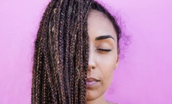 Beautiful mixed race girl with braids and pink background