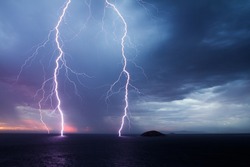Double lightning strike over the ocean at sunset