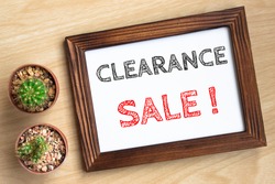 clearance sale, text message on wood frame board on wood table / business concept / Top view
