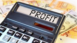 PROFIT text written on a calculator next to the background of euro banknotes. Finance or business concept.