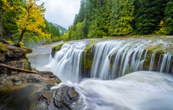 Beautiful river waterfall in autumn forest landscape