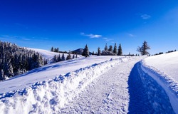 Winter snow path in sunny day. Wintry outdoors landscape in winter snow season. Snow path in winter landscape. Winter pathway snow