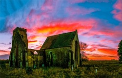 Ruins of an old church in a field at dawn. Ruins at dawn. Beautiful sunrise sky over ruins