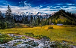 Mountain valley on a clear day. Beautiful valley in mountains. Mountain valley landscape. Snowy mountain peaks background
