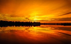 Beautiful sunset over the lake. Sunset lake water reflection. Lake at sunset. Orange sunset over lake water