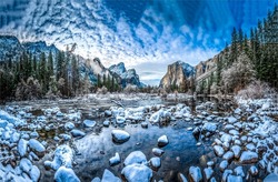 Snow on the rocks of a mountain river. Mountain forest river water in snow. Snowy mountain forest river valley. River stones in snow