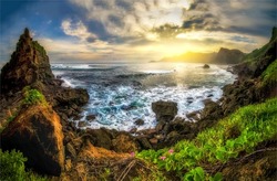 Sunrise on the horizon in a sea bay in the mountains. Beautiful coastline panorama at dawn. Sunrise sea coastal landscape. Mountain sea coast at dawn